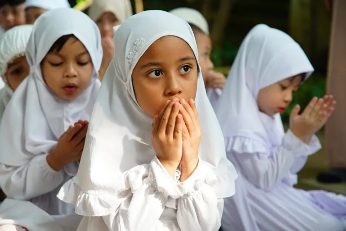 Children raising their hands in du'a